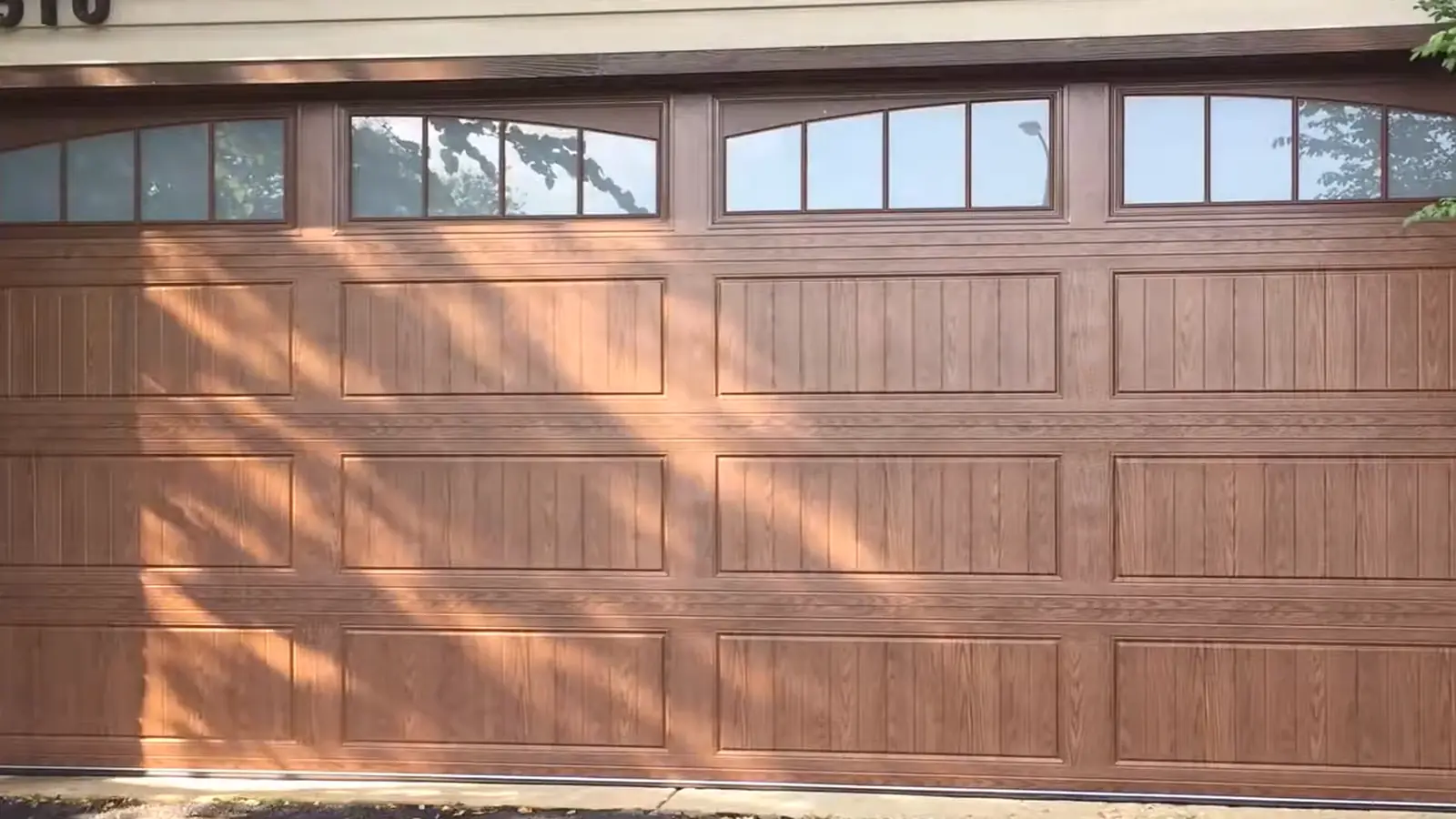 Wood raised-panel double garage door with upper windows in Greenwood Village