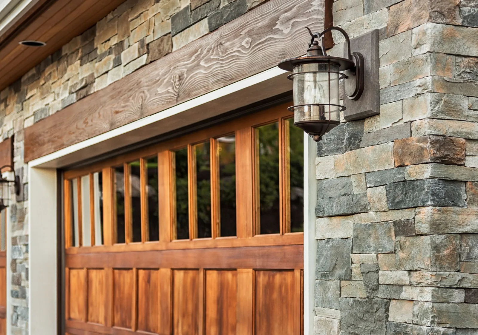 Garage door installation Littleton custom wood garage door detail on a stone exterior