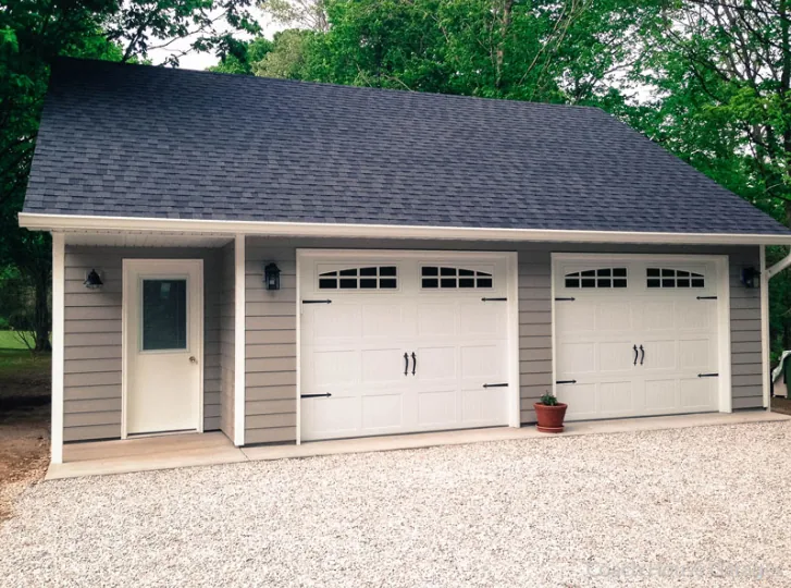 Two white carriage-style replacement garage doors in Littleton