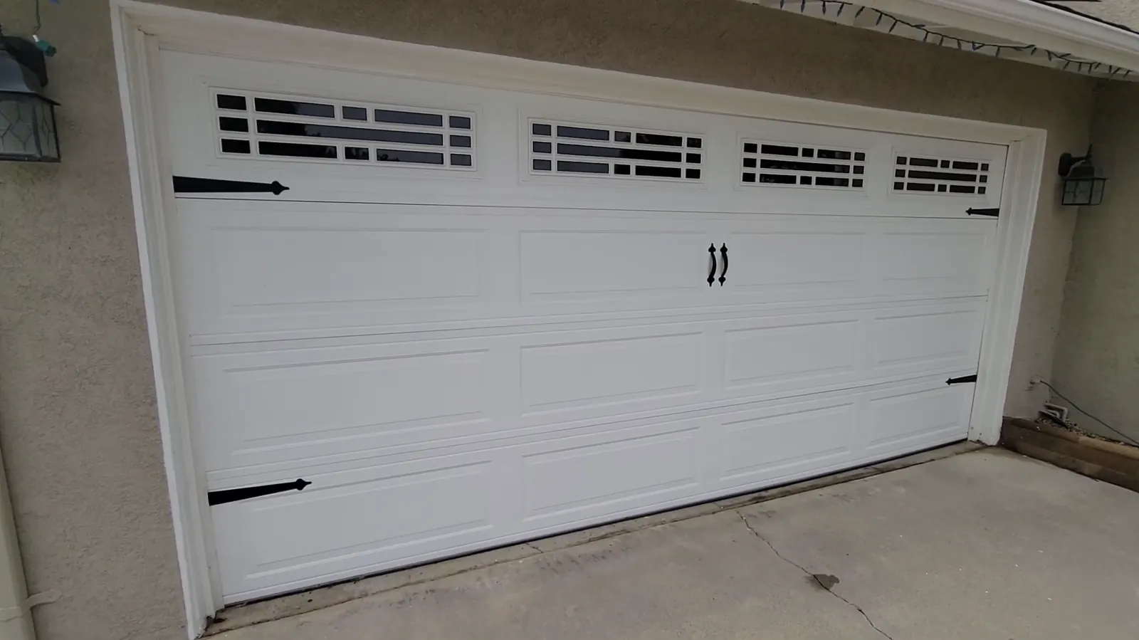White carriage-house garage door installation with decorative windows
